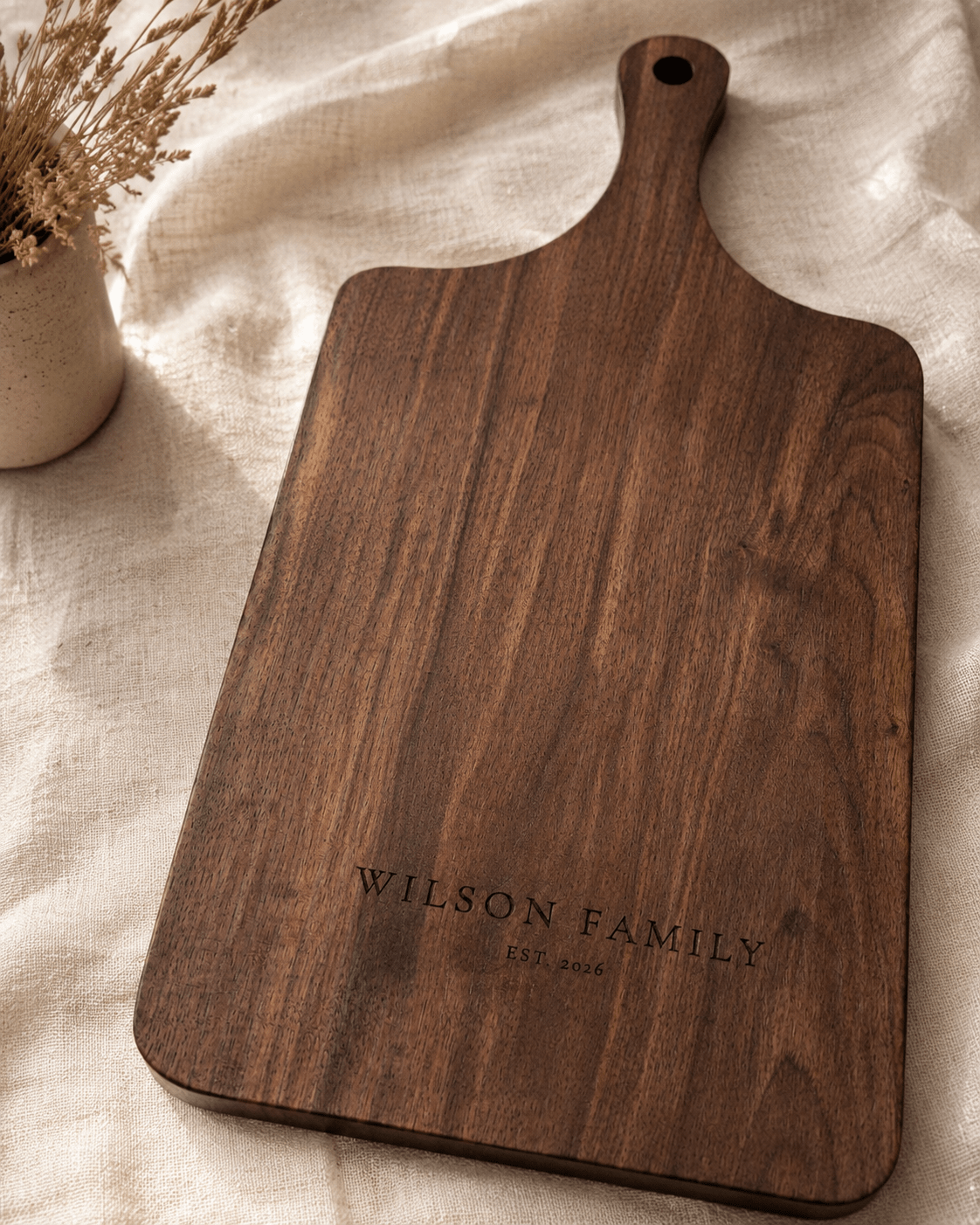 Close-up of personalized laser engraving on walnut cutting board